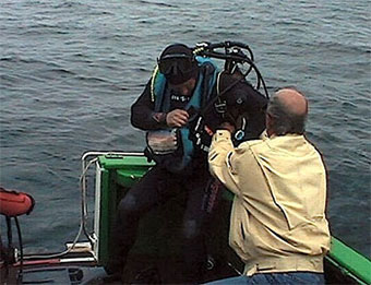 Serge Noirsain aide un plongeur qui refait surface. (Photo Gérard Hawkins)